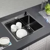 A kitchen sink with dishes drying in a rack, with a faucet running water. Produktbild-Vorschau