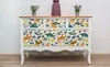 A dresser with a dinosaur pattern on the drawers, placed against a white wall. Produktbild-Vorschau