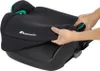Hands adjusting the cover of a black car seat booster with green accents. Produktbild-Vorschau
