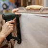 A person is using a staple gun to attach white batting to the frame of a piece of furniture. Produktbild-Vorschau
