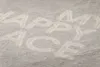 The image shows the words 'my happy place' written in a light color on a textured, light gray surface. The text appears to be made of a material like chalk or sand, suggesting it's a close-up of a surface where words have been inscribed. Produktbild-Vorschau
