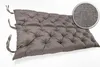 A gray tufted bench cushion with ties on a white background. Produktbild-Vorschau