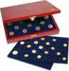 A wooden box with a lid open, revealing trays of coins inside. Two trays are also shown outside the box, also filled with coins. Produktbild-Vorschau