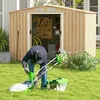 A person is working on a lawnmower in front of a storage shed. Podgląd zdjęcia produktu