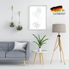 A modern living room scene featuring a gray sofa, a floor lamp, a small side table with a plant, and wall decor. Produktbild-Vorschau