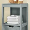 A close-up view of a gray bathroom cabinet with folded white towels on a shelf and a drawer below. Anteprima dell’immagine prodotto