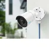 A white Reolink junction box is mounted on a white wall, with blue and black wires extending from it. Produktbild-Vorschau