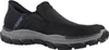 A black Skechers slip-on shoe with a gray sole is shown against a white background. Produktbild-Vorschau