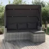 A grey poly rattan garden sofa with a canopy and footrest is shown on a wooden deck, surrounded by greenery. Produktbild-Vorschau