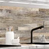 A close-up view of a kitchen backsplash with a wood plank design, featuring kitchenware and a faucet. Produktbild-Vorschau