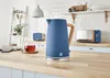 A kitchen counter with a blue kettle, a cup of tea, and other kitchen appliances in the background. Produktbild-Vorschau