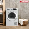 A white Telefunken dryer is shown in a laundry room setting, next to a shelf with folded towels and a basket of laundry. Produktbild-Vorschau