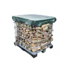A stack of firewood covered by a green tarp, contained within a metal cage. Podgląd zdjęcia produktu