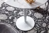 A close-up view of a white round table with a pedestal base, placed on a patterned rug. Náhľad obrázku produktu