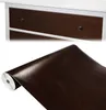 A roll of wood-grain contact paper is shown next to a close-up of drawers with the same wood-grain finish. Produktbild-Vorschau
