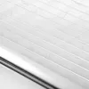 A close-up view of a white pleated blind with a silver metal bar along the bottom edge. Produktbild-Vorschau