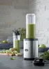 A WMF Kult X Mix & Go Mini Smoothie Maker is shown on a kitchen counter with ingredients for a smoothie. Produktbild-Vorschau