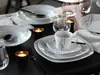 A table setting with plates, cups, cutlery, and candles. Náhľad obrázku produktu