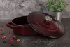 A burgundy Dutch oven is placed on a dark, textured surface, with its lid slightly ajar. Dried flower petals are scattered around the base of the pot, and a small potted plant is visible in the background. Produktbild-Vorschau