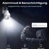 A security camera is shown illuminating a person's hand in the dark, with a notification alert displayed. Produktbild-Vorschau