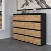 A modern dresser with a black frame and wood-effect drawers, displayed in a room setting with a mirror and artwork. Produktbild-Vorschau