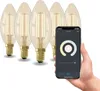 A hand holding a smartphone displaying a smart bulb app, with a set of smart LED filament bulbs in the background. Produktbild-Vorschau