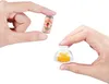 Hands holding miniature items, a can of Olipop and a jelly dessert under a cloche. Podgląd zdjęcia produktu