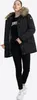 A woman wearing a black winter jacket and black pants, standing against a white background. Produktbild-Vorschau