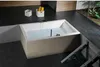 A modern bathroom with a built-in bathtub filled with water, two white baskets with yellow towels, and a view of plants through a window. Produktbild-Vorschau