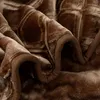 A close-up view of a brown, plush blanket with a textured pattern. Podgląd zdjęcia produktu