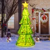 A lit-up Christmas tree decoration stands in the snow outside a house decorated for the holidays. Náhled obrázku produktu