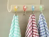 Four colorful clips holding up checkered towels on a wall-mounted rack. Anteprima dell’immagine prodotto