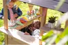 Two children playing with a wooden playhouse that resembles an ice cream stand. Produktbild-Vorschau