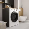 A modern laundry room or bathroom with a washing machine, toilet, and storage cabinets. Anteprima dell’immagine prodotto