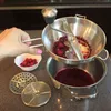 A hand is shown operating a food mill with raspberries, processing them into juice. Anteprima dell’immagine prodotto