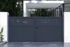 A modern, dark gray aluminum double gate with decorative cutouts at the top, set against a contemporary building entrance with white architectural elements and greenery. Produktbild-Vorschau