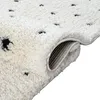 A close-up view of a rolled-up rug with a dotted pattern. Produktbild-Vorschau