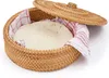 A round wicker basket with a lid, lined with a red and white checkered towel, containing a round, flat bread. Anteprima dell’immagine prodotto