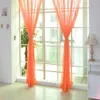 A bright room with large windows covered by orange sheer curtains. Produktbild-Vorschau