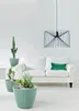 A living room scene with a white sofa, plants in pots, and a pendant light. Anteprima dell’immagine prodotto