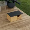 A wooden cat house with a black roof sits on a wooden deck next to a grassy area and potted plants. Náhled obrázku produktu