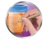 A hand is writing on a baby food container. Náhled obrázku produktu