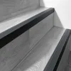 Close-up view of dark gray stair nosing strips on light gray wooden stairs. Anteprima dell’immagine prodotto