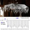 Icicle lights are installed on an outdoor umbrella at night. Produktbild-Vorschau
