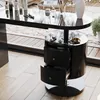 A black high-gloss vanity table with drawers and jewelry on display, set against a backdrop of a patio or balcony with wooden flooring and large windows. Podgląd zdjęcia produktu
