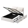 A white upholstered bed frame with the mattress support lifted to reveal storage space and drawers. Produktbild-Vorschau