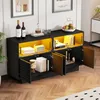 A black sideboard with yellow interior, displaying books, wine bottles, and decorative items. The doors are open, revealing the interior storage. Produktbild-Vorschau