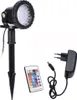 A garden spotlight with its accessories, including a remote control and power adapter, displayed against a white background. Produktbild-Vorschau