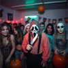 A group of young people at a Halloween party, some in costumes, with pumpkins and decorations. Anteprima dell’immagine prodotto