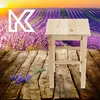 A wooden stool sits on a wooden floor in front of a lavender field at sunset. Voir les images du produit